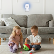 Two children playing on the floor with a toy in a living room, featuring a Pyle motion sensor light.